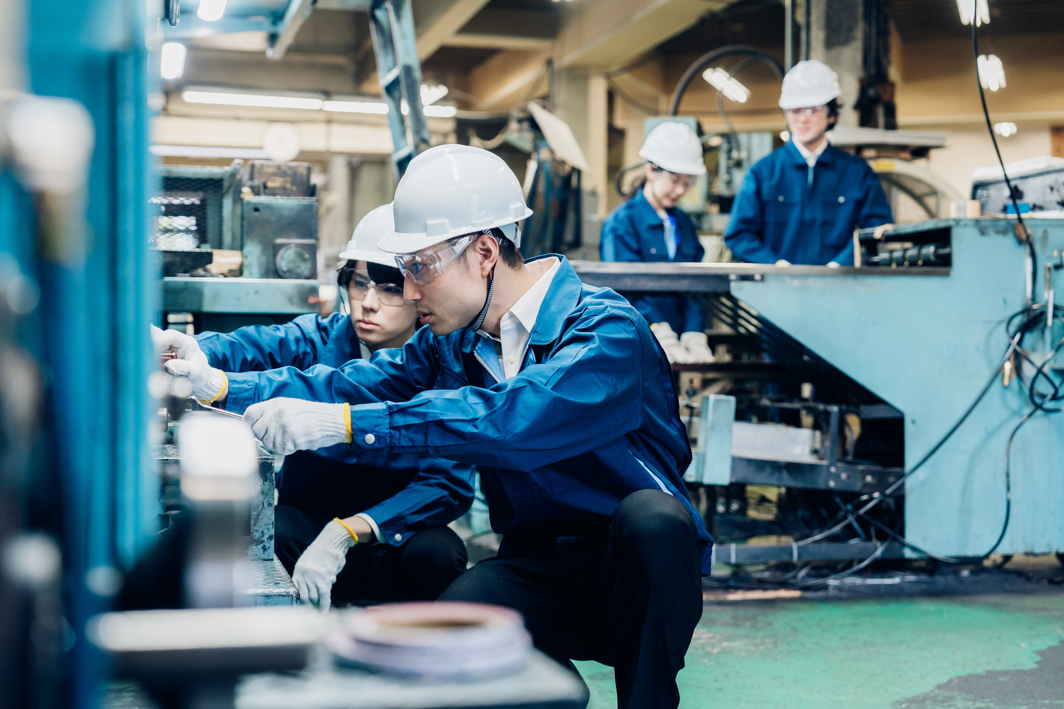 Lithium refinery workers in blue uniform and white safety helmet working on the machine in the lithium refinery.
